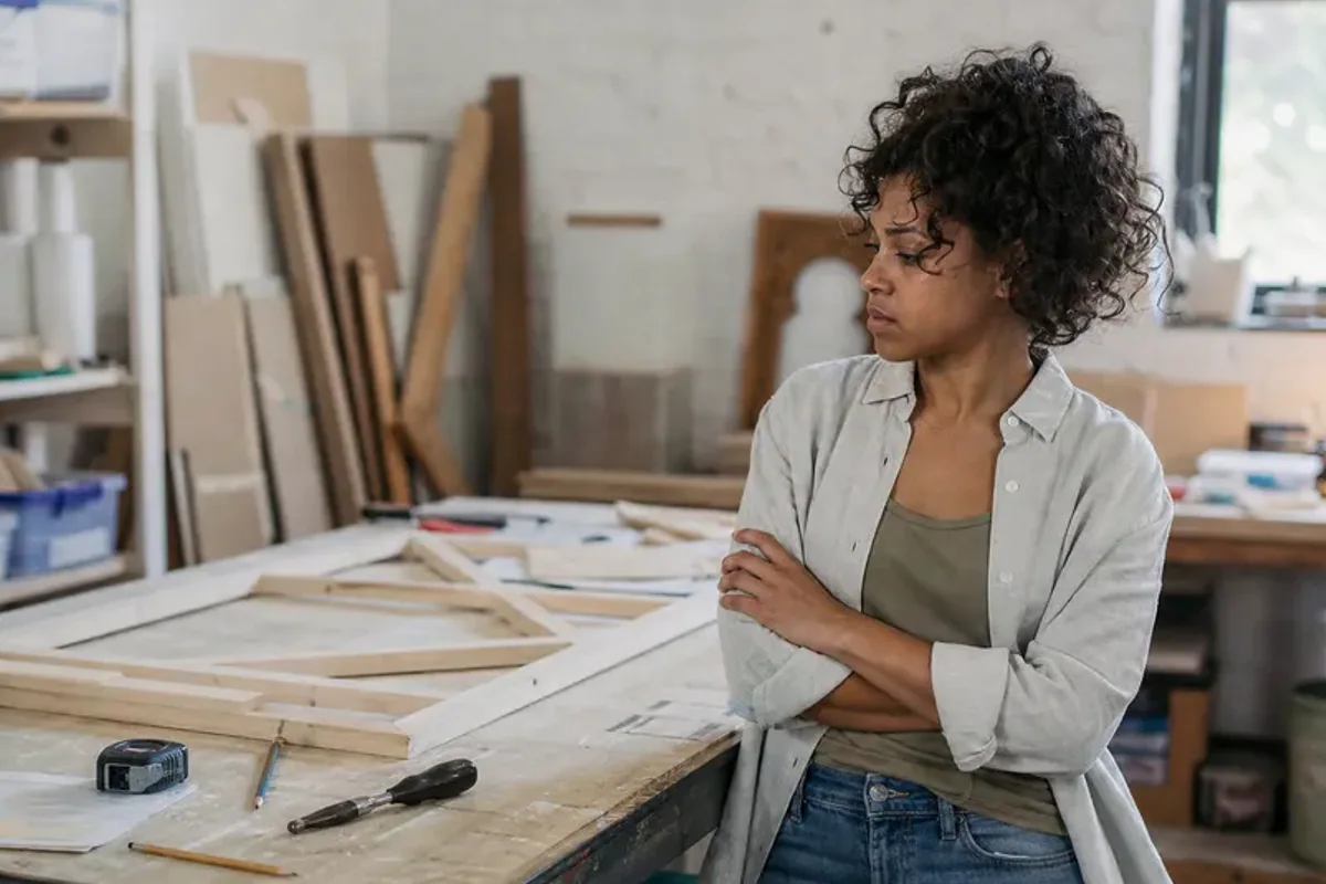 A person at a sunlit desk placing a phone face down and opening a notebook to one simple task.