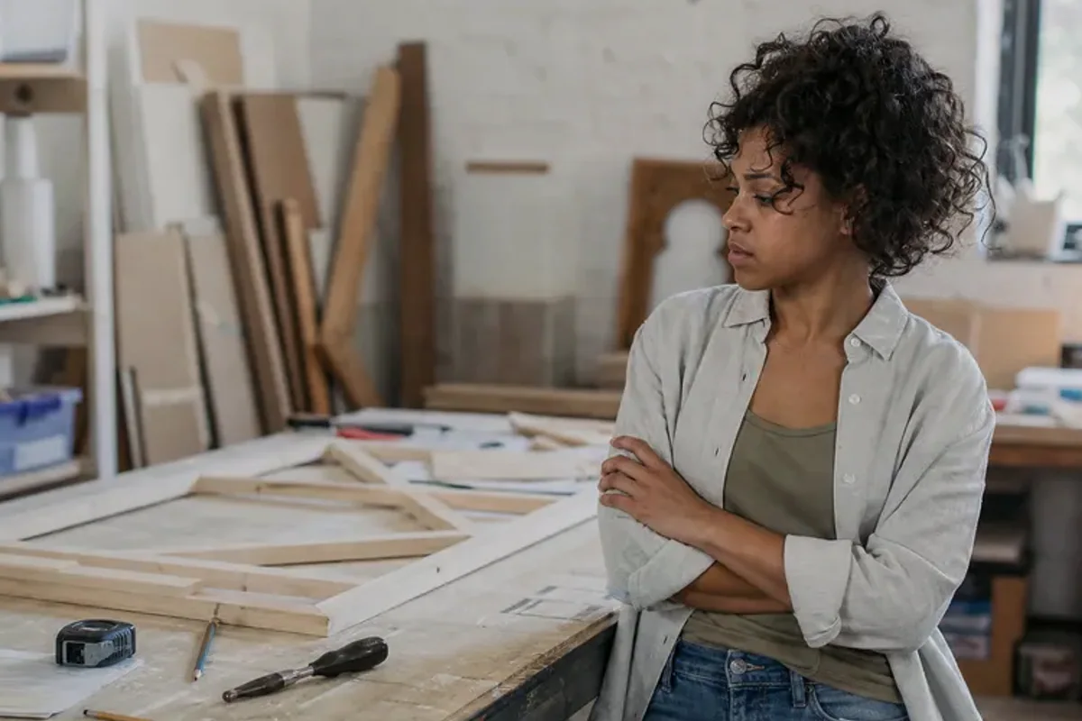 A person at a sunlit desk placing a phone face down and opening a notebook to one simple task.