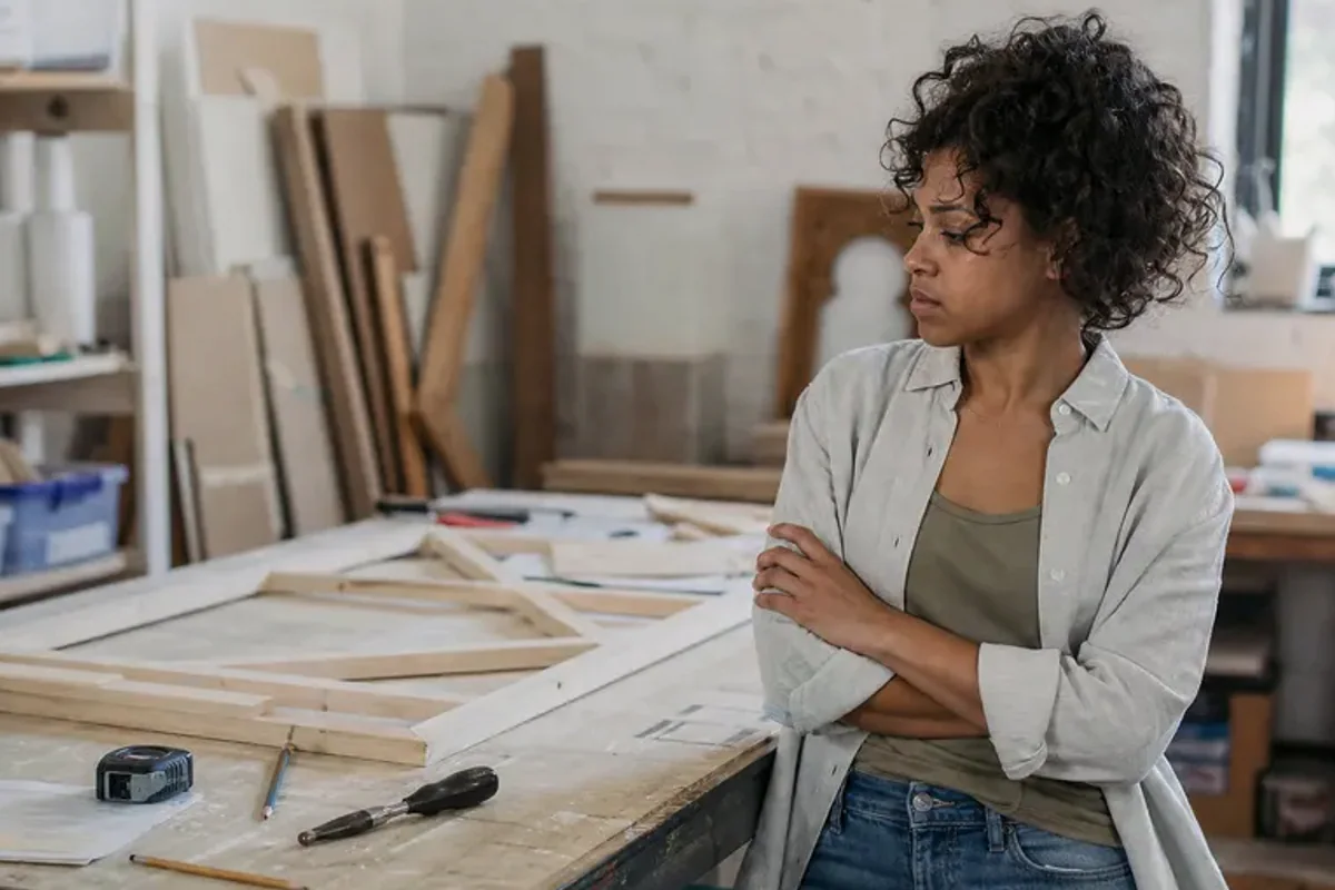 A person at a sunlit desk placing a phone face down and opening a notebook to one simple task.